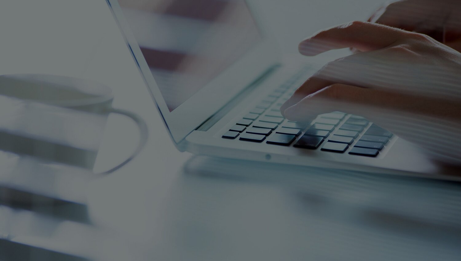 Nahaufnahme von Händen, wie sie etwas am Laptop eintippen